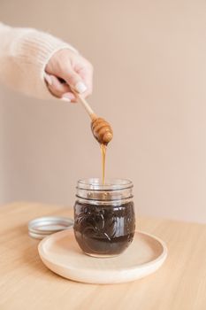 Dark amber honeydew honey in a glass jar